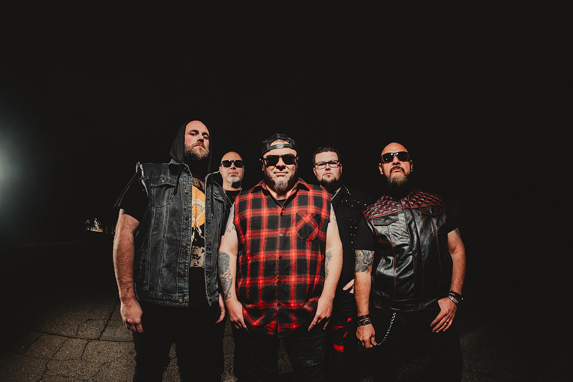 TangenT, five band members standing in a dark room