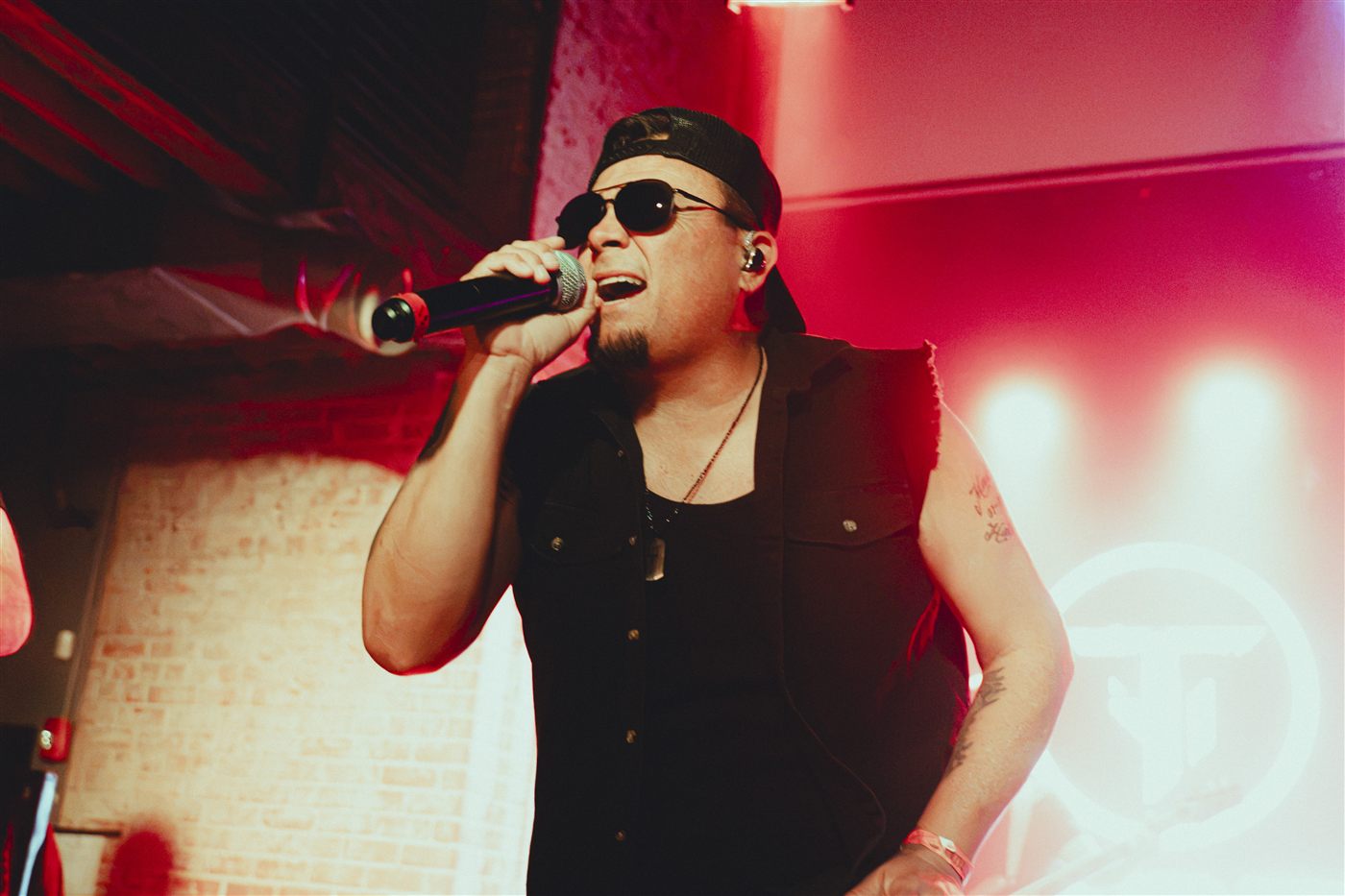 Singer belting into the mic in red light